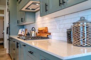 A close-up image of a new light blue cabinets and a white backsplash.