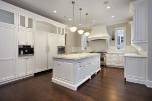 A recently remodeled kitchen with white cabinets and wood floors.
