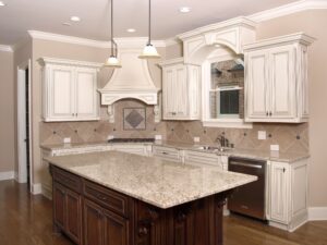 A remodeled kitchen with white cabinets and pendant lighting.